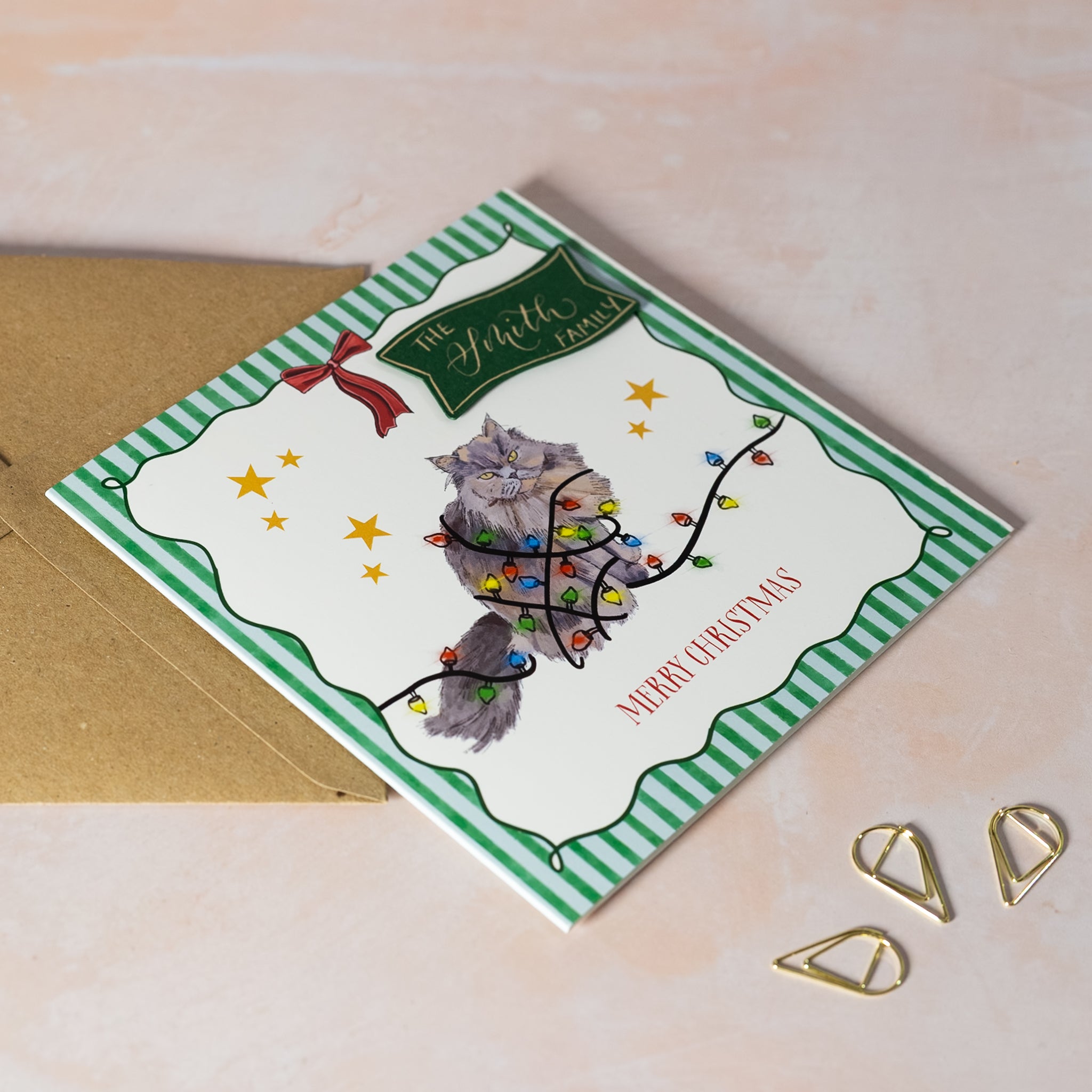 Christmas card with a cat in lights illustration with personalised calligraphy name
