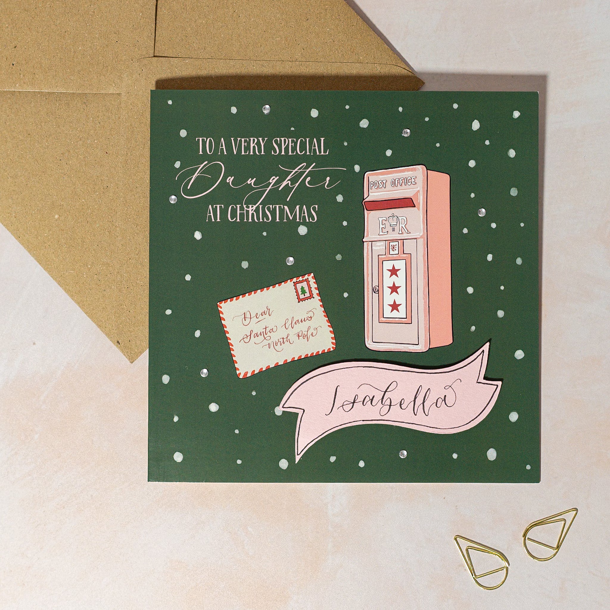 Personalised Christmas card with a pink mailbox illustration on a green background with snow in background and handwritten calligraphy name