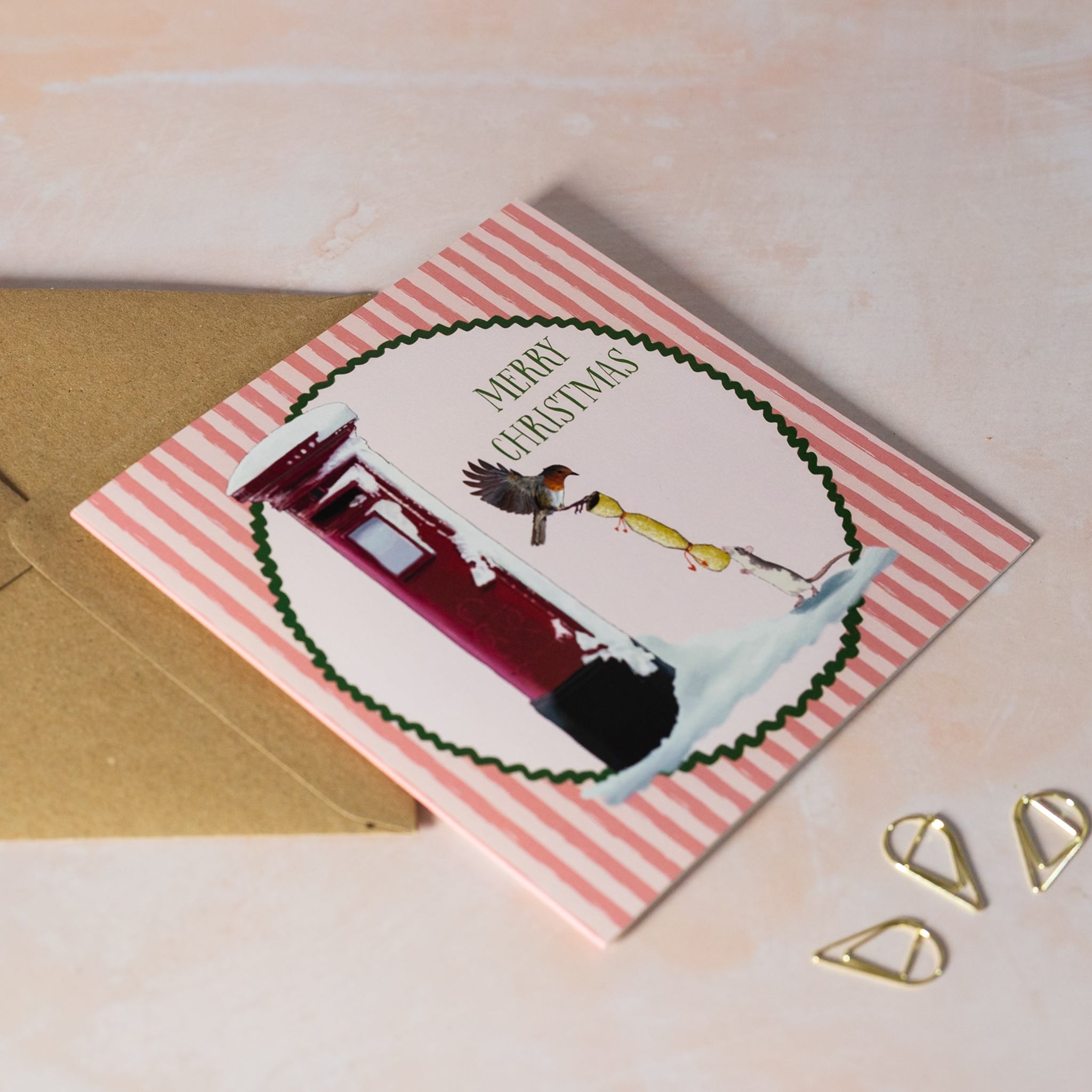 Christmas card with a robin and mouse pulling a cracker next to red post box.