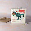 Christmas card with a dinosaur holding a gift box. Personalised calligraphy name.