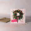 Christmas card with a wreath design on a pink background