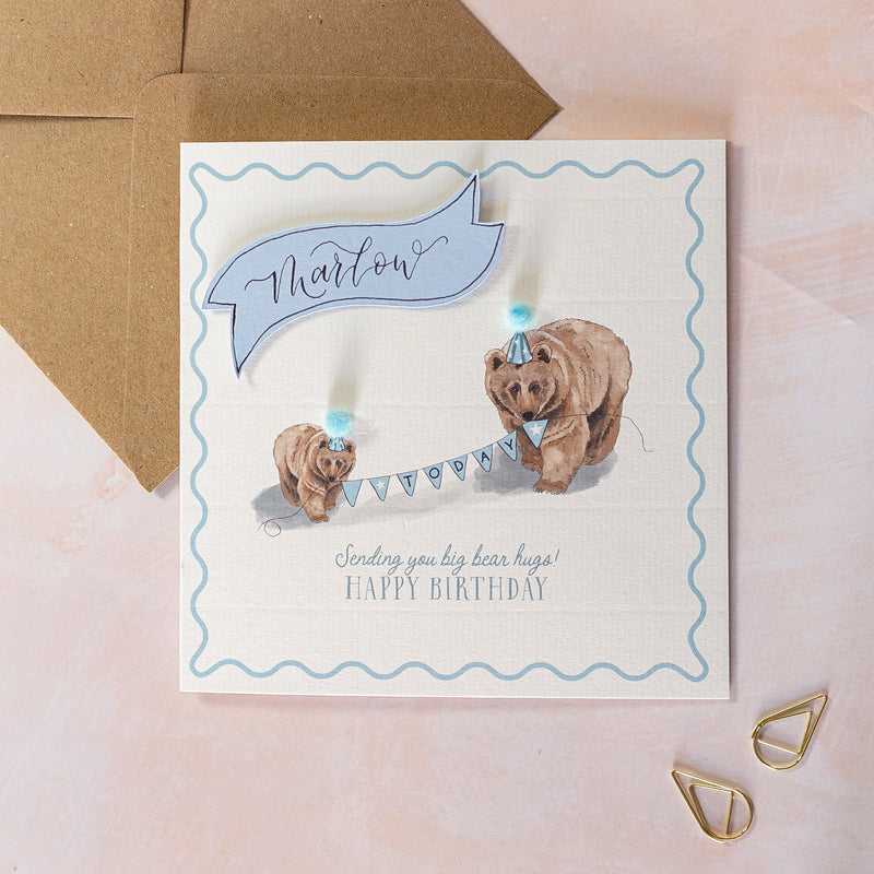 Birthday card with two bears holding a banner and wearing party hats